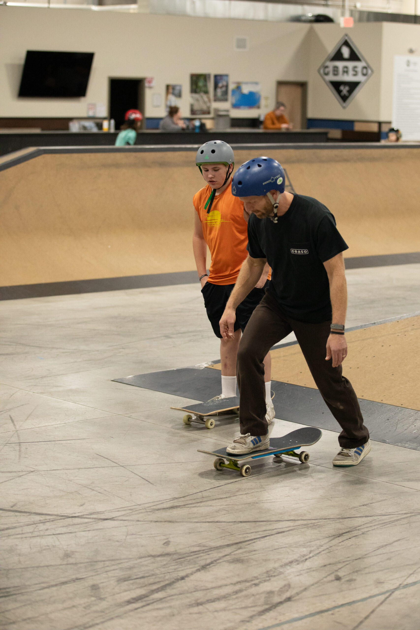 Coach Eric teaching a student to push off on a skateboard