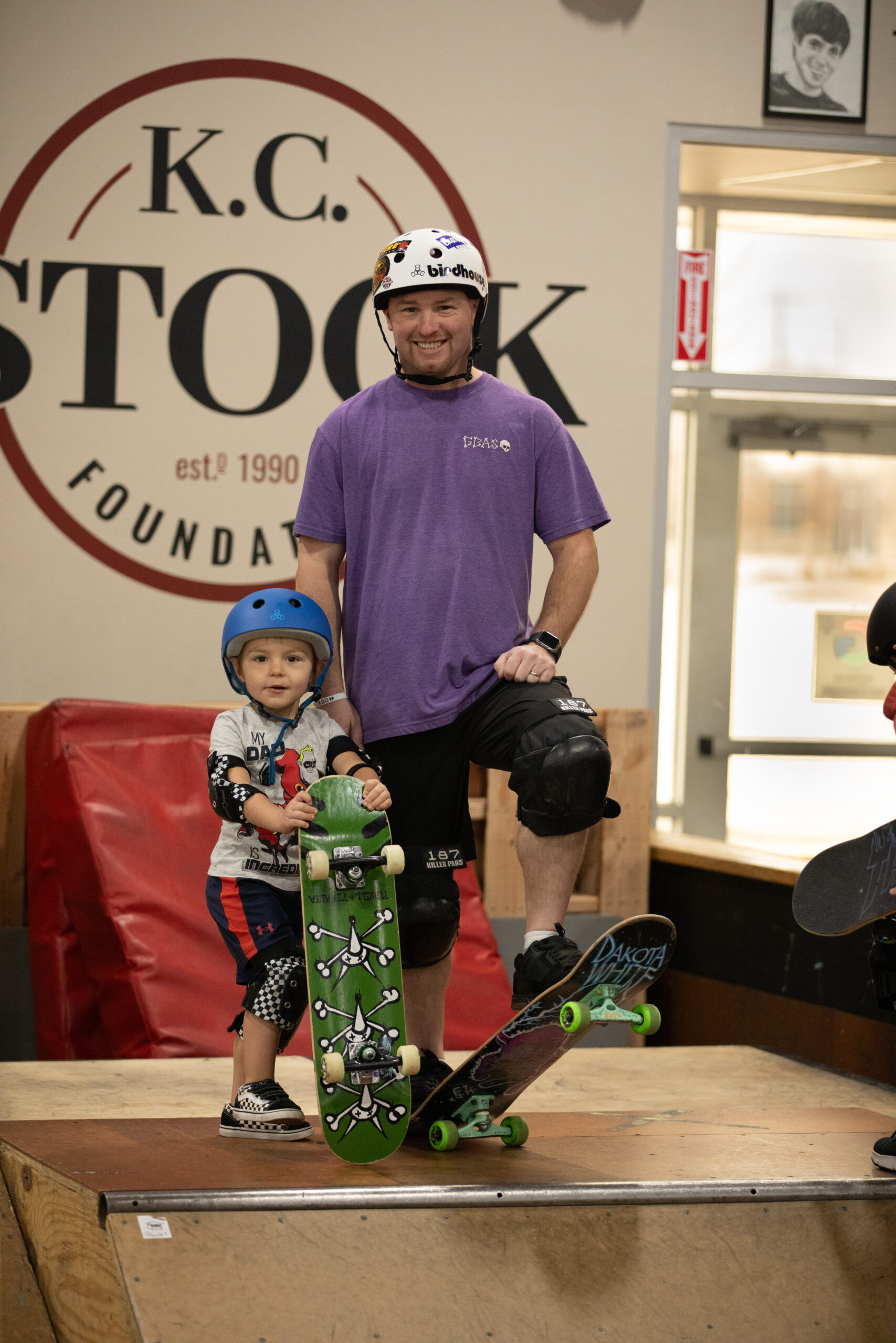 Coach Andrew with his young son standing on top of a skateboard ramp