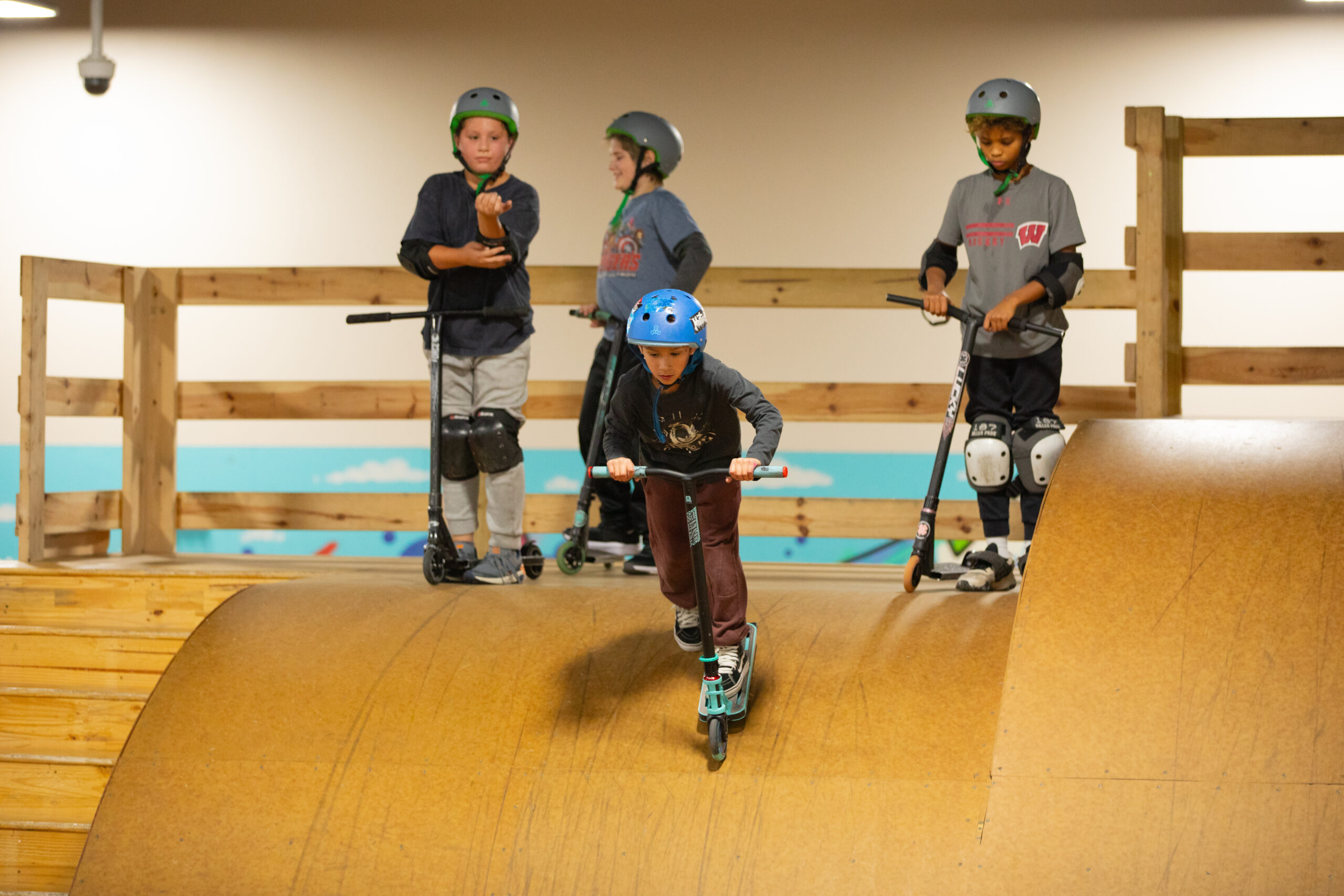 Scooter riders prepare to roll in down a ramp