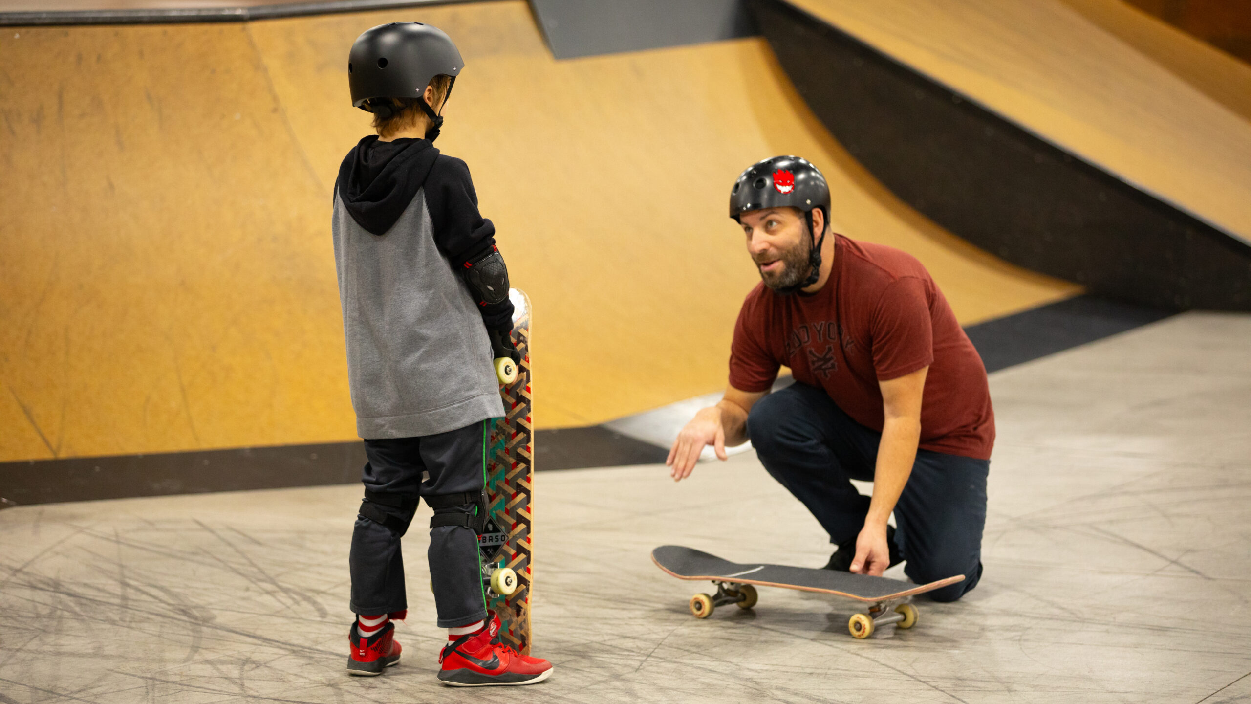 a student receiving skate tips from a coach