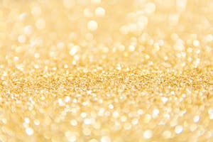 Abstract gold glitter background with a bokeh effect, ideal for festive designs.
