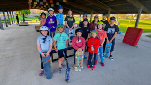 A group of riders pose in front of a mobile skate ramp