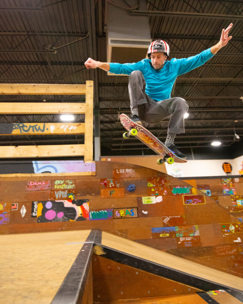 A skateboarder does an olly in the street section at GBASO
